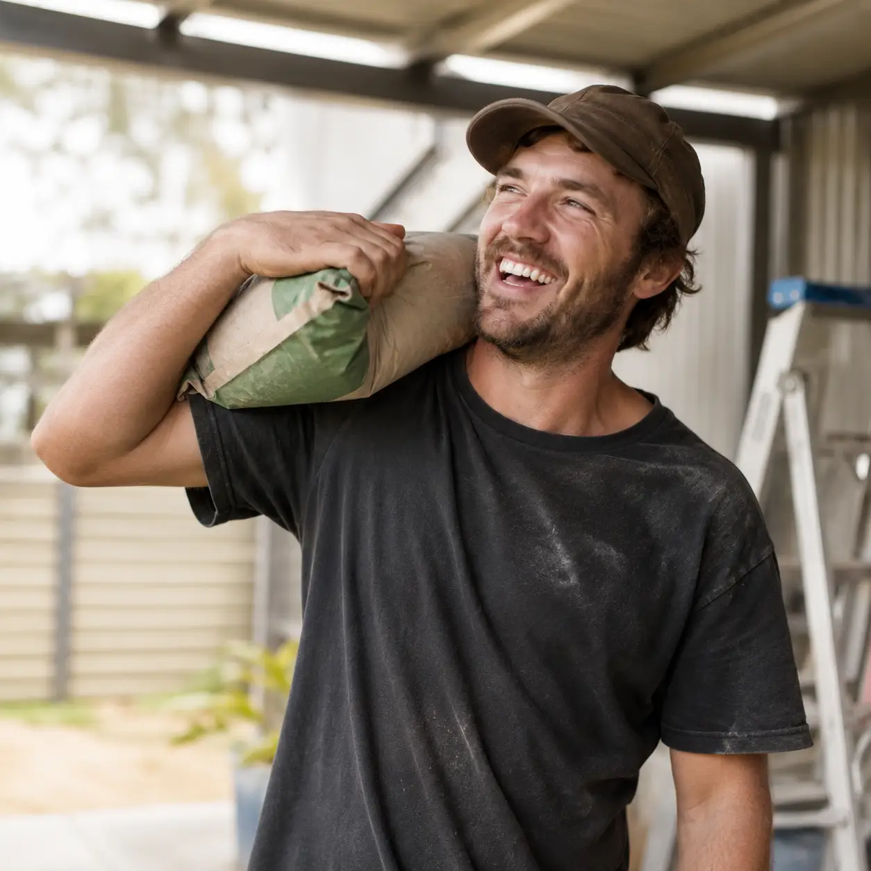 Young Australian man with cement bag over his shoulder